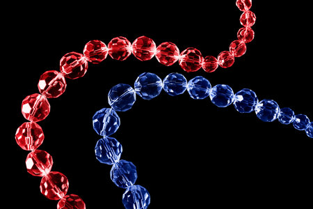 Strings of red and blue faceted crystals on black backgroundの写真素材