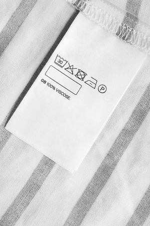 Composition and care clothes label on striped textile backgroundの写真素材