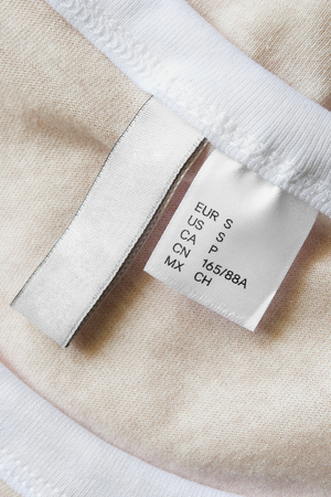 Small size clothes label on beige textile backgroundの写真素材