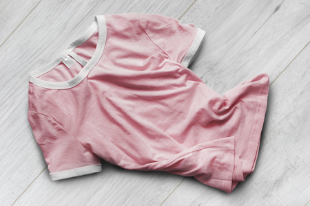 Crumpled pink basic t-shirt on white wooden backgroundの写真素材