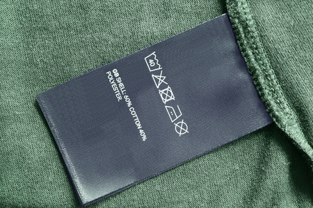 Care and composition clothes label on green textile background closeupの写真素材