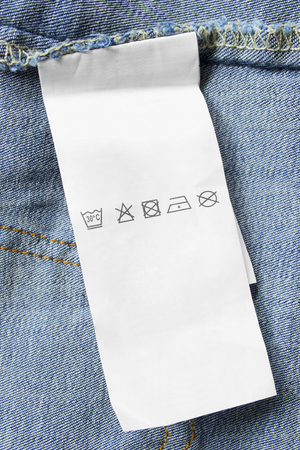 Care clothes label on blue denim background closeupの写真素材
