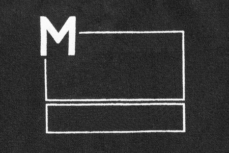 M size blank frame clothes label on black textile backgroundの写真素材