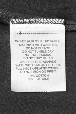 Care and composition clothes label on black textile background closeupの写真素材