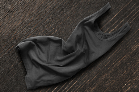 Crumpled black basic tank top on dark wooden backgroundの写真素材