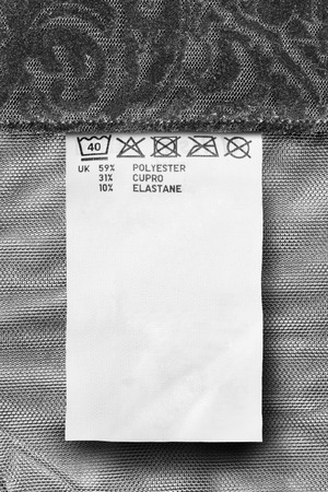 Composition and care clothes label on black textile background closeupの写真素材