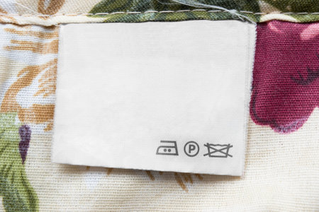 Care clothes label on colorful textile background closeup