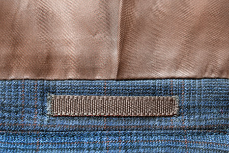 Blank brown textile patch on textile background closeup