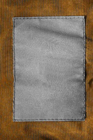 Blank textile clothes label on yellow textile background closeupの写真素材