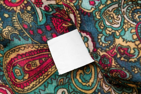 Blank white clothes label on colorful textile background