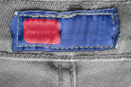 Blank textile clothes label on grey cotton background closeupの写真素材