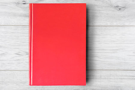 Red blank book on white wooden background