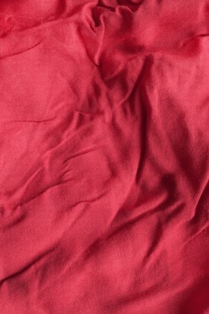 Crumpled red silk closeup as a backgroundの写真素材