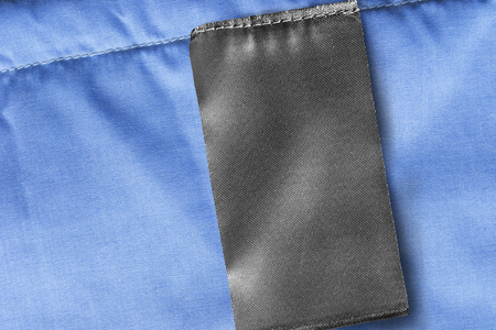 Blank black textile clothes label on blue textile closeupの写真素材