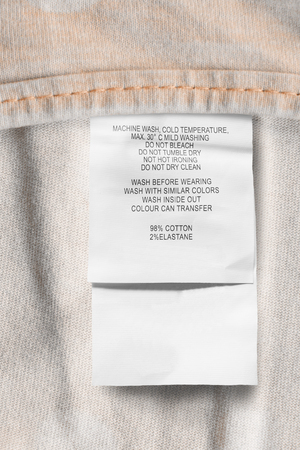 Care and composition clothes label on yellow textile closeupの写真素材