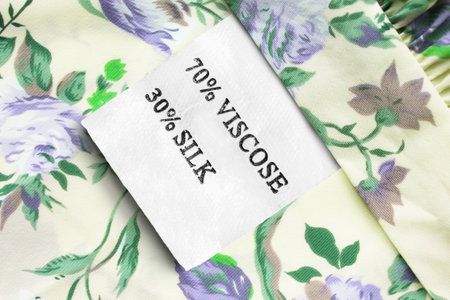 Composition clothes label on yellow and green floral textile background