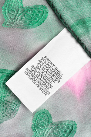 Composition clothes label on green and pink textile background