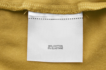 Composition clothes label on yellow extile background closeup