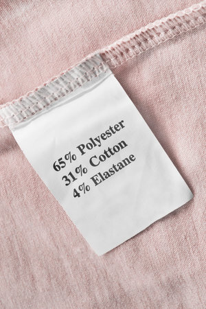 Fabric composition clothes label on pink textile background