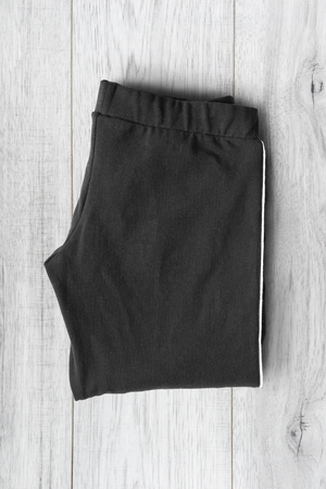 Folded black sport pants on white wooden backgroundの写真素材