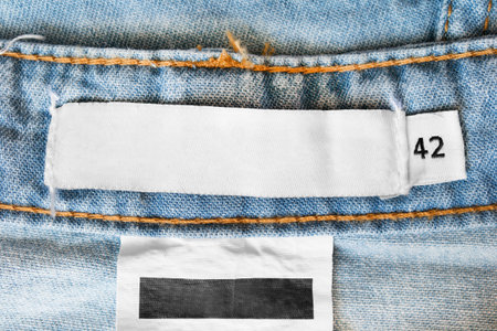42 size textile clothes label on denim background closeup