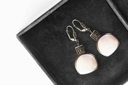 Pair of elegant white enamel earrings in black jewel boxの写真素材