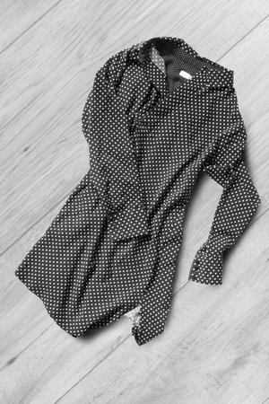 Black and white crumpled silk blouse on white wooden background