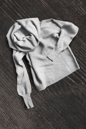 Wool grey crumpled sweater on dark brown wooden backgroundの写真素材