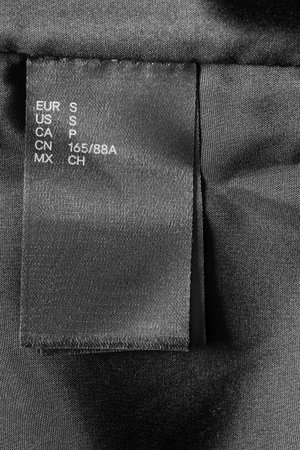 Small size black clothes label on black textile background