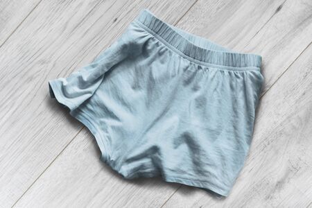Crumpled blue sport shorts on white wooden backgroundの写真素材