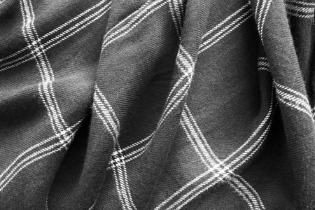 Draped plaid black and white fabrics closeup as a background
