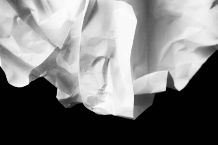 Abstract white blank crumpled paper on black as a backgroundの写真素材