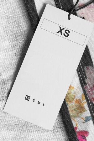 XS size clothes label closeup on textile backgroundの写真素材