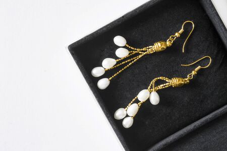 Vintage drop white peral gold earrings in black jewel box closeupの写真素材