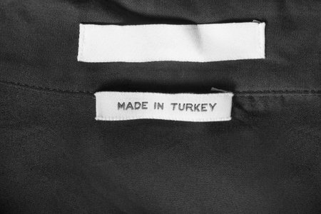 Clothes label says made in Turkey on black textile background
