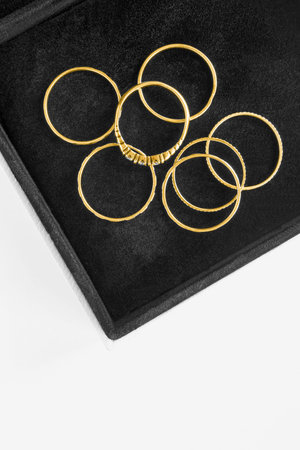Group of gold rings in black jewel box closeup