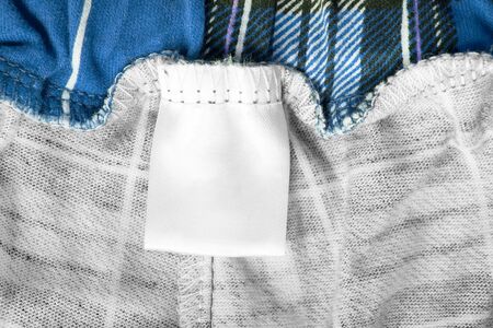 Blank clothes label on blue cotton tartan backgroundの写真素材