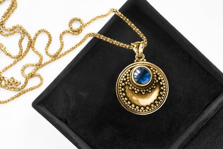 Vintage gold necklace with blue sapphire pendant in black jewel boxの写真素材