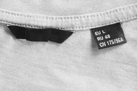 L size clothes label on white textile knitted backgroundの写真素材