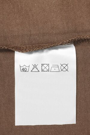 Care clothes label on brown textile background closeupの写真素材