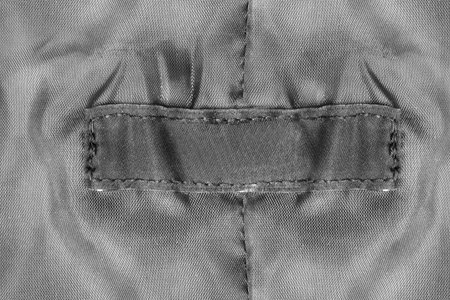 Blank black textile patch on black textile background