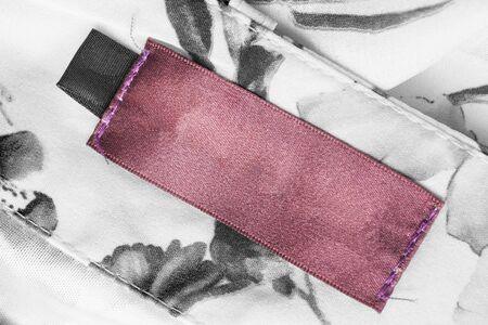 Blank pink clothes label on white and black textile backgroundの写真素材