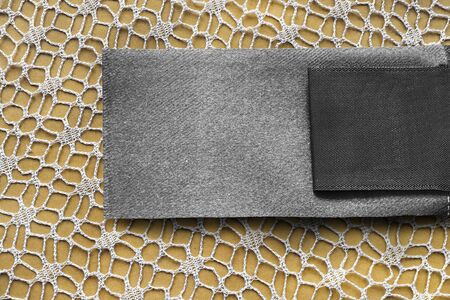Blank textile clothes label on yellow lacy background closeupの写真素材