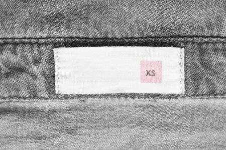 XS size clothing label on grey denim backgroundの写真素材