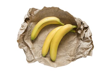 Three yellow bananans wrapped in craft paper on white backgroundの写真素材