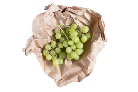 Green grapes wrapped in craft paper isolated over whiteの写真素材