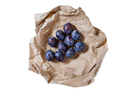 Blue sweet plums wrapped in craft paper isolated over whiteの写真素材