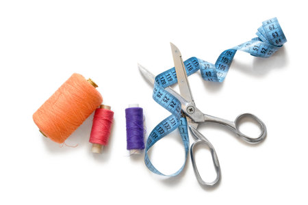 Tape measure, spools and scissors on white background