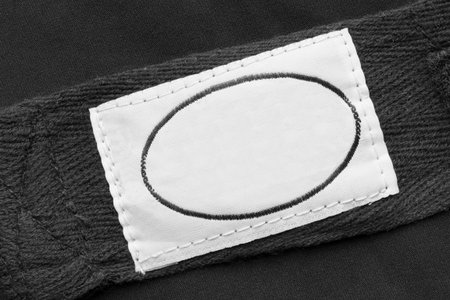 White blank textile clothing label on black textile background