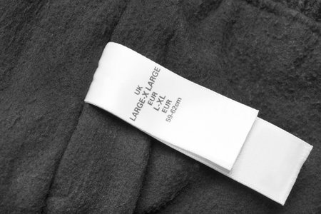 Size XL clothing label on black textile background